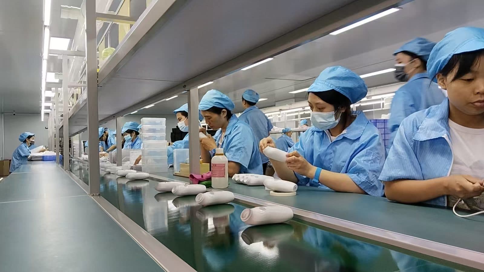 Assembly workers in caps, masks and gowns at SiLeap's baby nasal aspirator production line